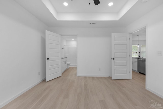 1581 Kyle Dr, Pensacola, FL 32505 - unfurnished bedroom featuring light wood-style floors, a tray ceiling, baseboards, recessed lighting, and ensuite bath
