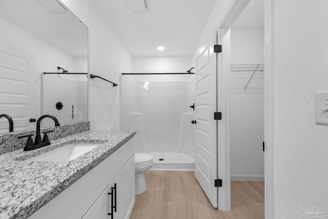 1581 Kyle Dr, Pensacola, FL 32505 - full bath with wood finished floors, a stall shower, toilet, vanity, and a spacious closet