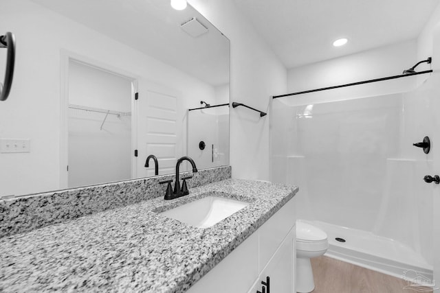 1581 Kyle Dr, Pensacola, FL 32505 - bathroom featuring a stall shower, vanity, toilet, a spacious closet, and wood finished floors