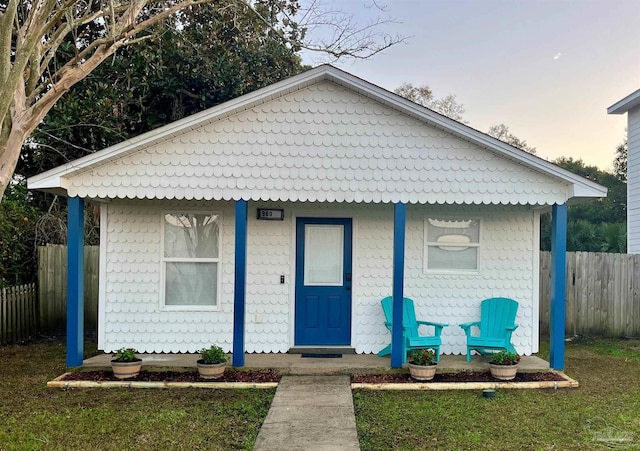 bungalow-style house with a porch and fence