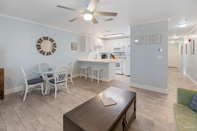 living room with light wood-type flooring, ceiling fan, sink, and ornamental molding