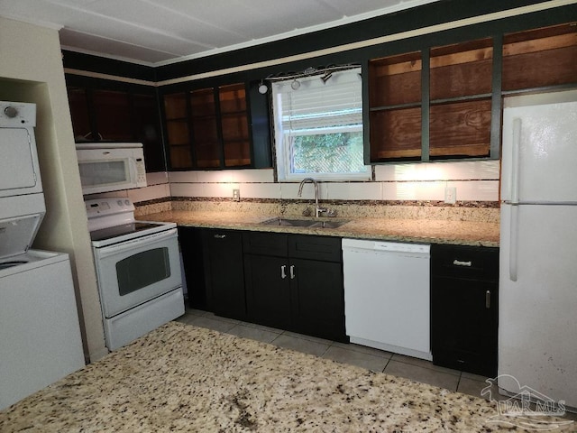729 Lownde Ave, Pensacola, FL 32507 - kitchen featuring white appliances, estacked washer and dryer, a sink, light tile patterned floors, and light stone countertops