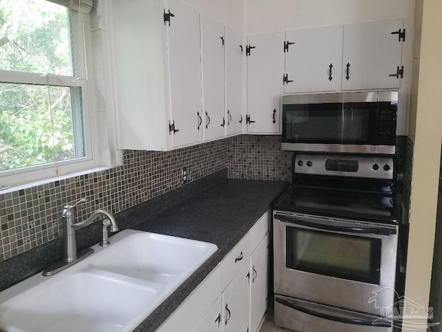 729 Lownde Ave, Pensacola, FL 32507 - kitchen featuring stainless steel appliances, a sink, white cabinetry, and backsplash