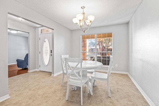 dining space featuring a textured ceiling and a notable chandelier