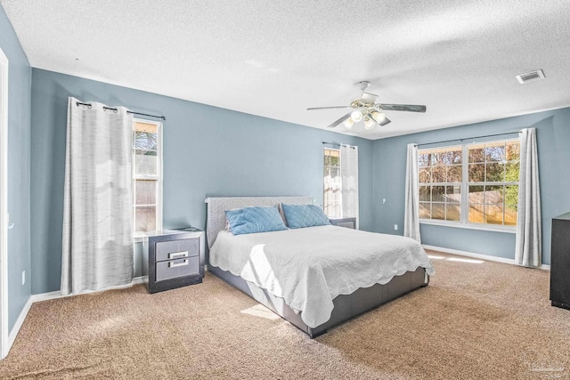 bedroom featuring ceiling fan, carpet floors, and a textured ceiling