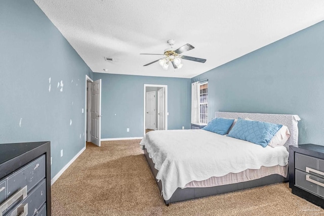 carpeted bedroom with ceiling fan and a textured ceiling