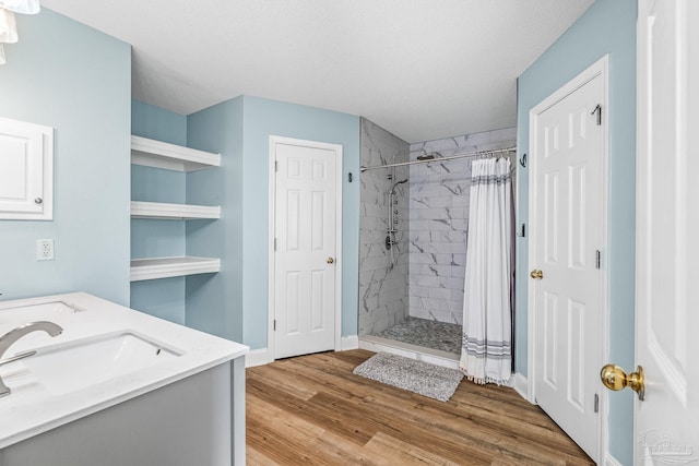 bathroom with a shower with shower curtain, vanity, a textured ceiling, and hardwood / wood-style flooring