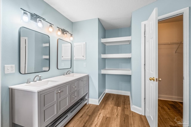 bathroom featuring hardwood / wood-style floors, vanity, and a textured ceiling