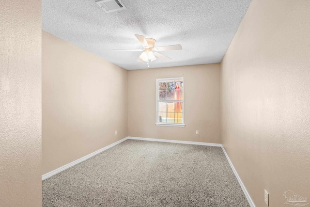 empty room with ceiling fan, carpet floors, and a textured ceiling