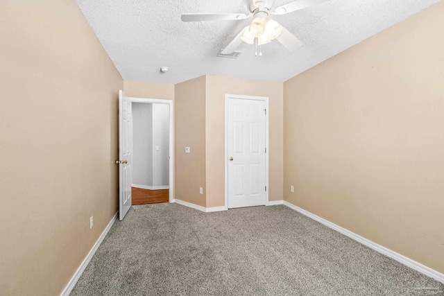 unfurnished bedroom featuring ceiling fan, carpet floors, and a textured ceiling