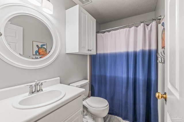 bathroom featuring vanity, a textured ceiling, and toilet