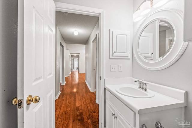 bathroom featuring hardwood / wood-style floors, vanity, and a textured ceiling