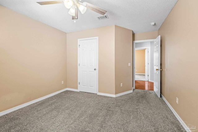 unfurnished bedroom featuring carpet, ceiling fan, and a textured ceiling