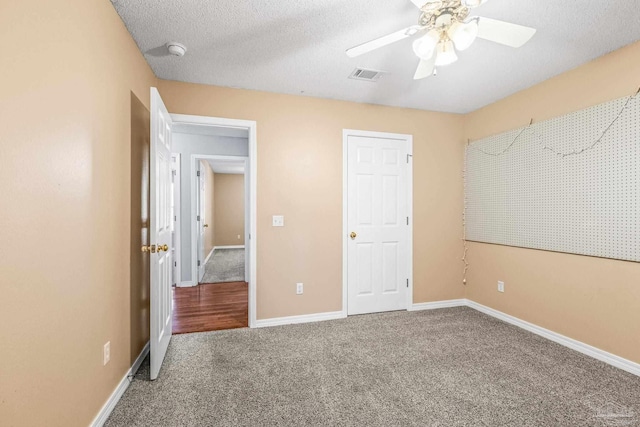 unfurnished bedroom featuring carpet, ceiling fan, and a textured ceiling