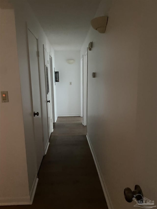 hall with dark wood finished floors and baseboards