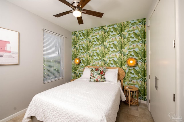 bedroom featuring a ceiling fan, baseboards, and wallpapered walls