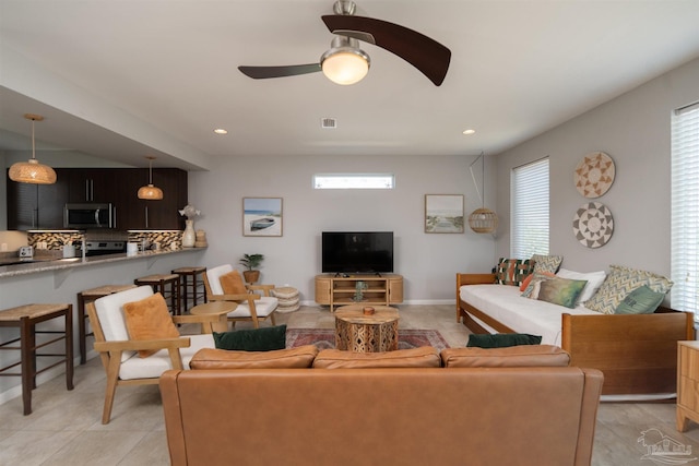 living area featuring baseboards, a ceiling fan, and recessed lighting