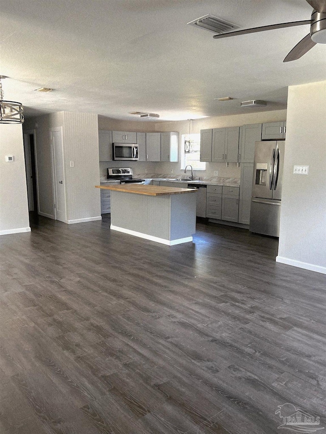 4285 W Avenida De Golf, Pace, FL 32571 - kitchen featuring appliances with stainless steel finishes, gray cabinetry, wooden counters, and a center island