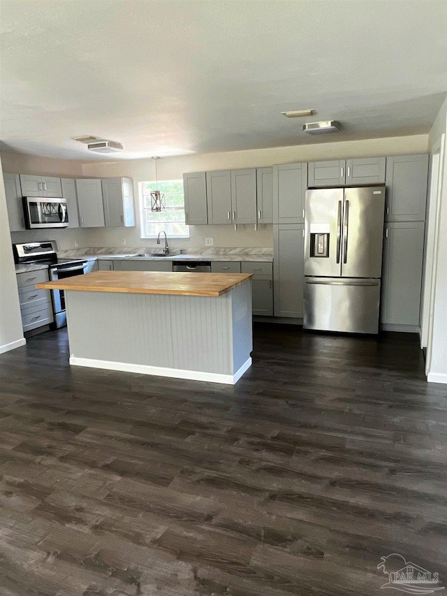 4285 W Avenida De Golf, Pace, FL 32571 - kitchen with stainless steel appliances, wood counters, gray cabinets, a sink, and dark wood finished floors