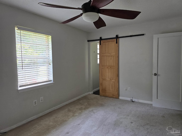 4285 W Avenida De Golf, Pace, FL 32571 - unfurnished bedroom with multiple windows, carpet, a barn door, and a textured ceiling