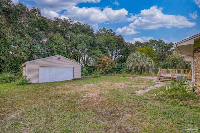 view of yard with a deck, a garage, and an outdoor structure