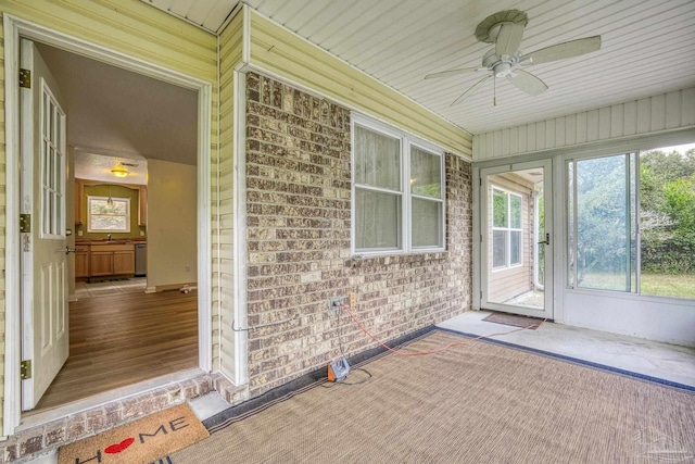 unfurnished sunroom with ceiling fan