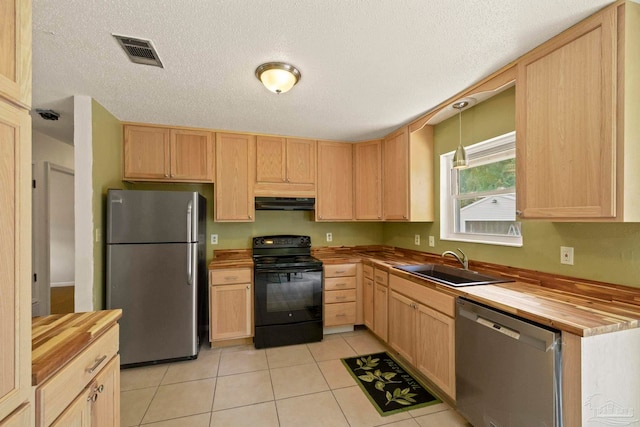 kitchen featuring light brown cabinetry, sink, stainless steel appliances, and wood counters