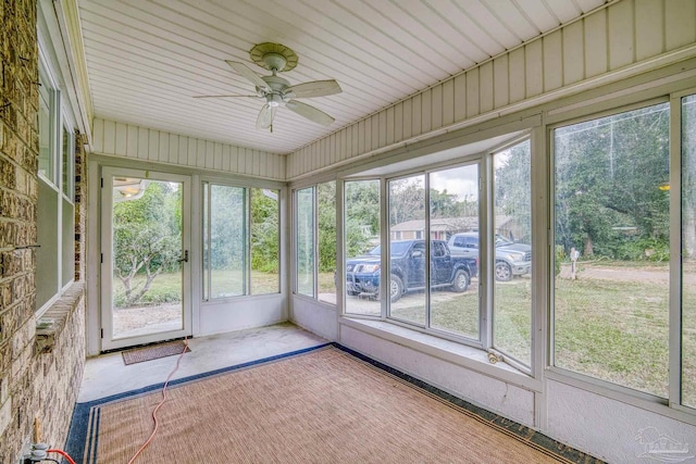 unfurnished sunroom featuring ceiling fan and a healthy amount of sunlight