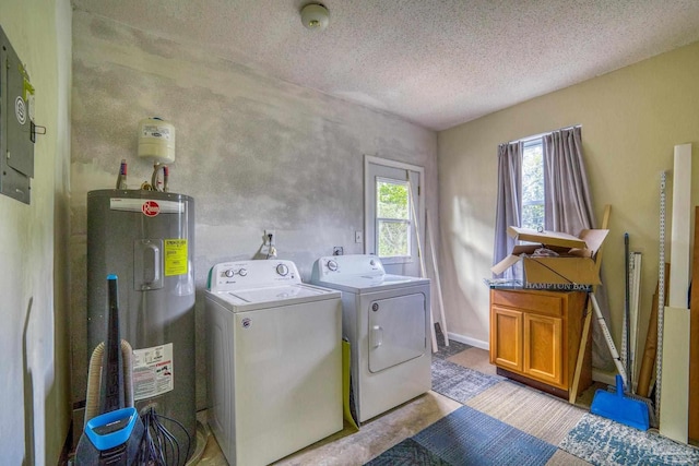 laundry room with washer and dryer, a textured ceiling, and water heater