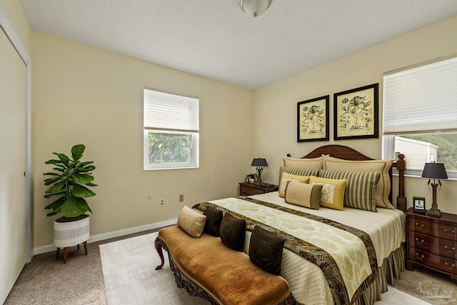 bedroom with light carpet and a textured ceiling