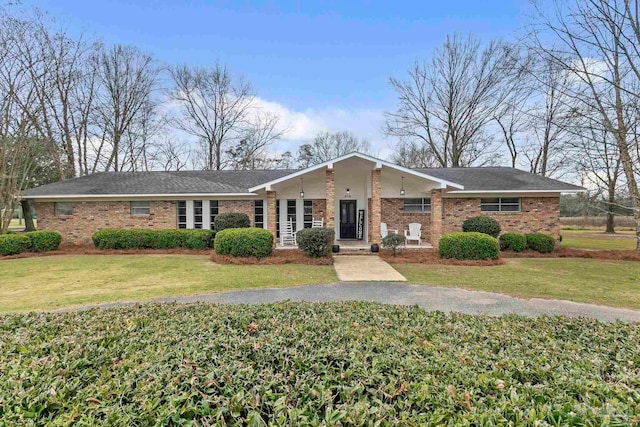 ranch-style home featuring a front lawn and brick siding