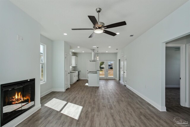 unfurnished living room featuring hardwood / wood-style flooring, french doors, and ceiling fan