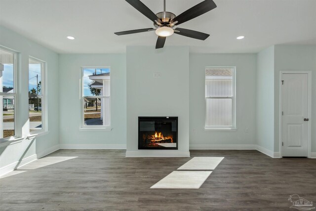 unfurnished living room featuring ceiling fan and hardwood / wood-style floors