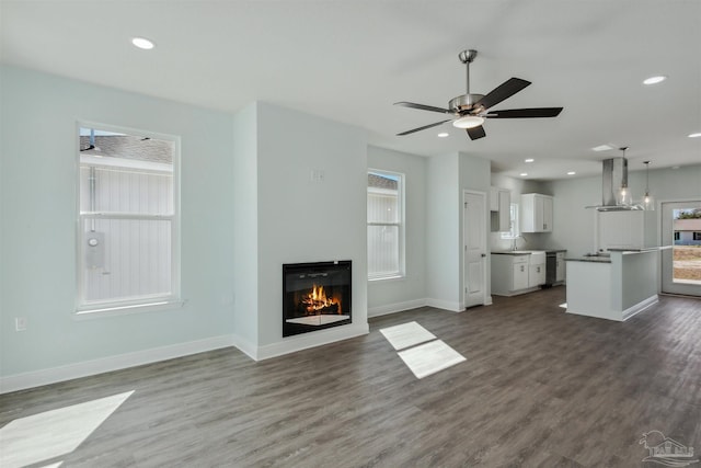 unfurnished living room featuring recessed lighting, baseboards, and dark wood-style flooring