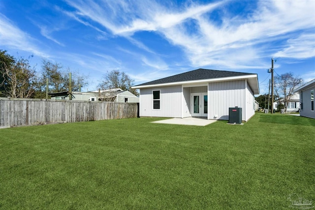 rear view of property with a yard, a patio, and central AC