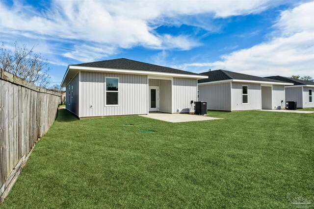 rear view of house with central AC, a patio, and a lawn