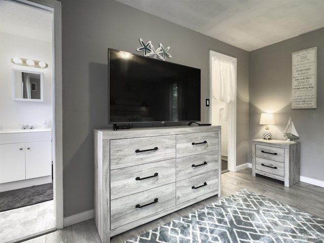 bedroom featuring hardwood / wood-style floors and ensuite bath