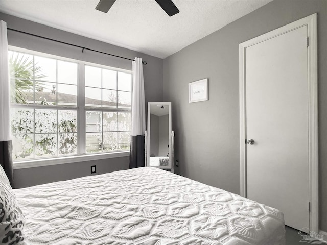 bedroom with ceiling fan and a textured ceiling