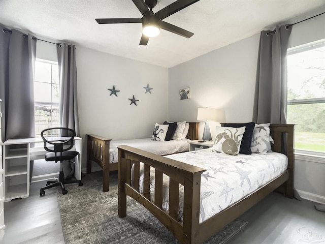 bedroom with hardwood / wood-style floors, a textured ceiling, and ceiling fan