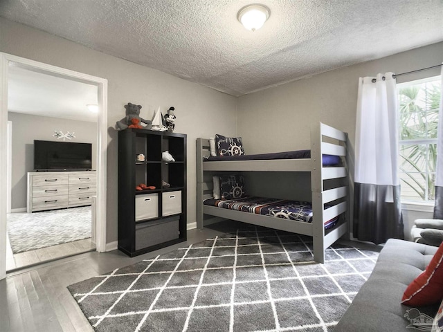 bedroom featuring dark hardwood / wood-style flooring and a textured ceiling