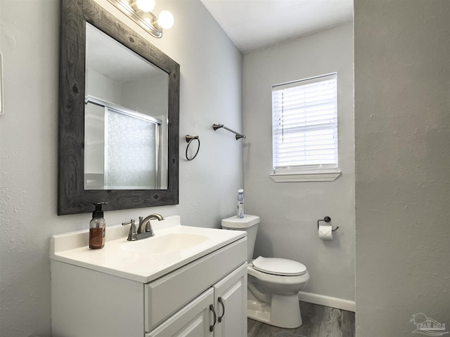 bathroom with hardwood / wood-style flooring, vanity, and toilet