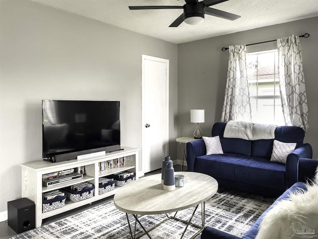 living room with ceiling fan and a textured ceiling