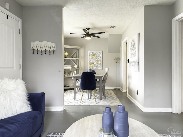 dining space with ceiling fan and a textured ceiling