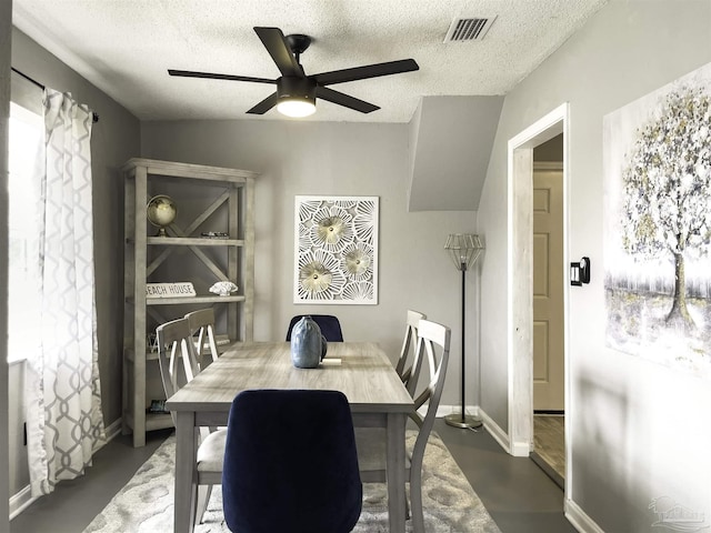 dining area featuring ceiling fan and a textured ceiling