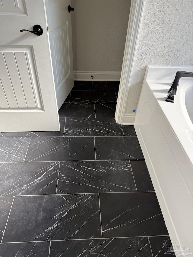 7919 Twin Lake Dr, Milton, FL 32583 - bathroom featuring marble look tile flooring and baseboards