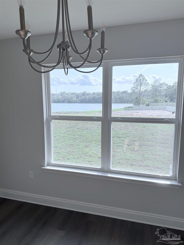7919 Twin Lake Dr, Milton, FL 32583 - unfurnished dining area with a chandelier, dark wood-type flooring, a water view, and baseboards