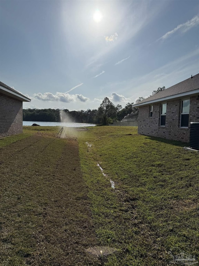 7919 Twin Lake Dr, Milton, FL 32583 - view of grassy yard featuring central air condition unit and a water view