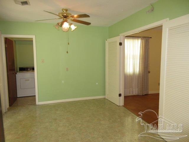 unfurnished room featuring washer / clothes dryer and ceiling fan