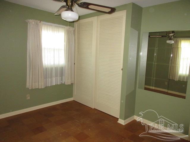 unfurnished bedroom featuring ceiling fan and a closet