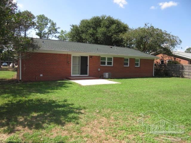 rear view of property featuring a yard, a patio, and central AC